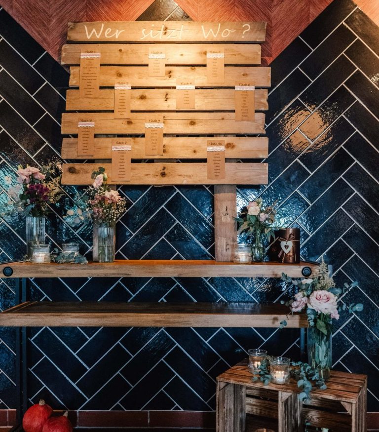 Holzregal mit Vasen und Kerzen in modernem, stilvollem Raum - Wer sitzt wo-Schild.